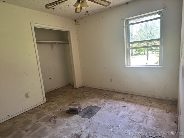 unfurnished bedroom featuring a textured ceiling, a closet, and ceiling fan