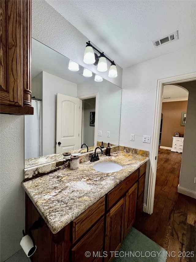 2516 Stage Coach Ave, Durant, OK 74701 - bathroom featuring visible vents, baseboards, a textured ceiling, vanity, and wood finished floors