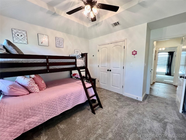 2516 Stage Coach Ave, Durant, OK 74701 - carpeted bedroom with a closet, baseboards, a ceiling fan, visible vents, and a tray ceiling