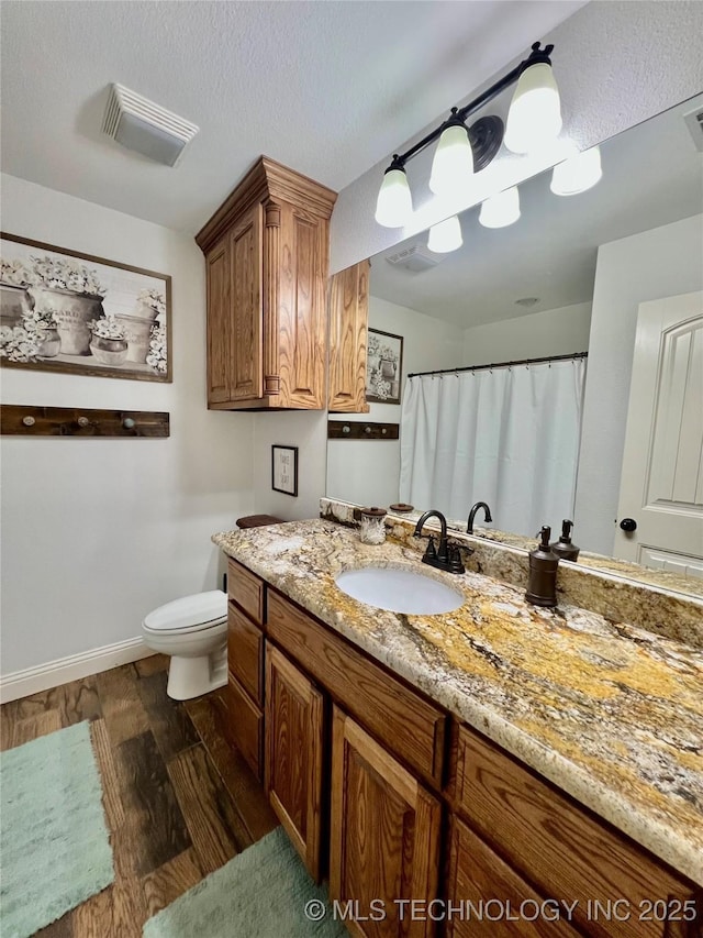 2516 Stage Coach Ave, Durant, OK 74701 - bathroom featuring visible vents, baseboards, toilet, vanity, and wood finished floors