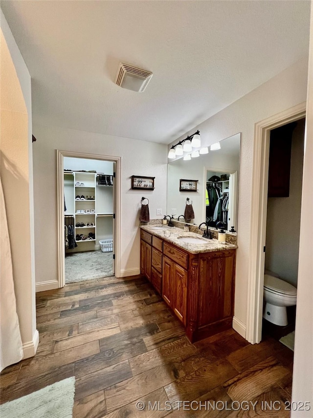 2516 Stage Coach Ave, Durant, OK 74701 - full bath featuring visible vents, a sink, toilet, and wood finished floors