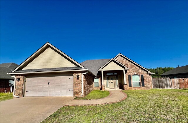 2516 Stage Coach Ave, Durant, OK 74701 - view of front of property featuring a front yard, fence, brick siding, an attached garage, and driveway