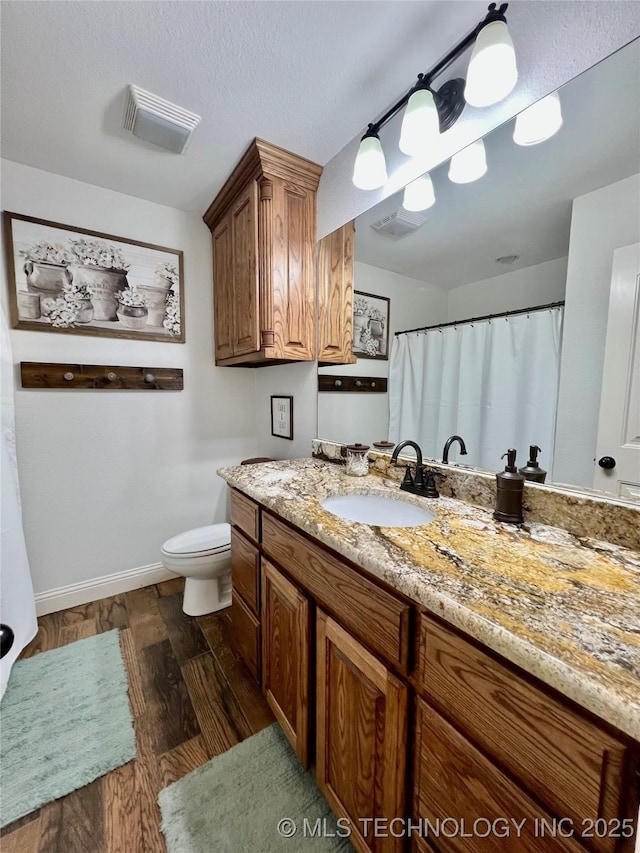 2516 Stage Coach Ave, Durant, OK 74701 - full bathroom featuring vanity, baseboards, toilet, visible vents, and wood finished floors