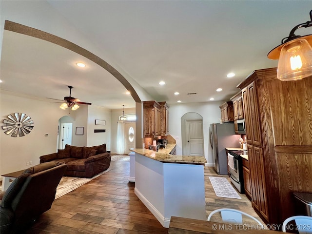 2516 Stage Coach Ave, Durant, OK 74701 - kitchen with open floor plan, arched walkways, dark wood finished floors, and stainless steel appliances