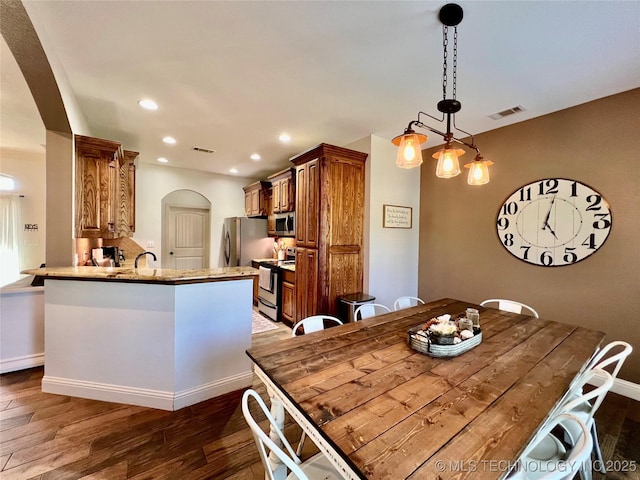 2516 Stage Coach Ave, Durant, OK 74701 - dining space featuring visible vents, baseboards, arched walkways, recessed lighting, and wood finished floors
