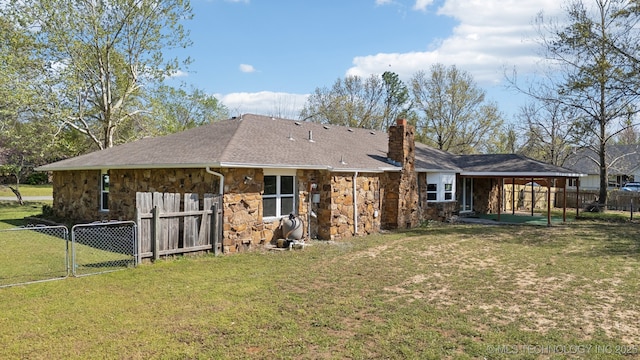 10785 E Dogwood Ct, Claremore, OK 74019 - rear view of property featuring a yard, fence, stone siding, and a chimney