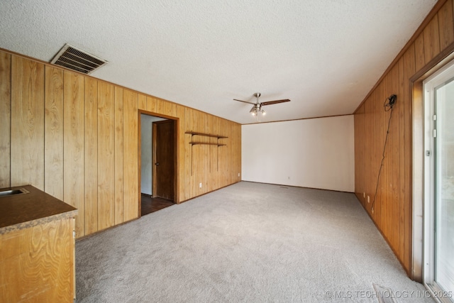 10785 E Dogwood Ct, Claremore, OK 74019 - interior space featuring wooden walls, visible vents, a textured ceiling, and ceiling fan