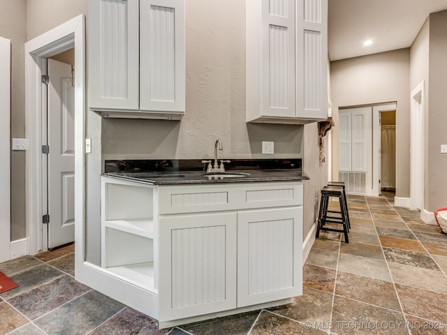 263 Eagles Nest Path, Stigler, OK 74462 - kitchen featuring dark countertops, stone tile flooring, and a sink