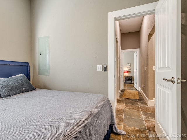 263 Eagles Nest Path, Stigler, OK 74462 - bedroom with baseboards, stone tile floors, and electric panel
