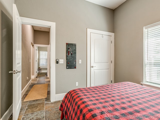 263 Eagles Nest Path, Stigler, OK 74462 - bedroom with stone tile floors, baseboards, and multiple windows