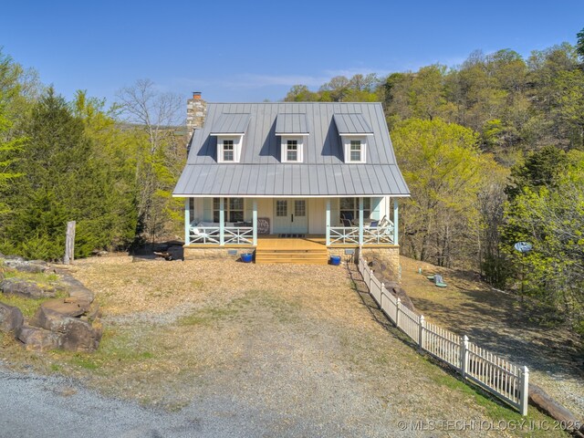 263 Eagles Nest Path, Stigler, OK 74462 - view of front facade featuring a standing seam roof, a porch, metal roof, fence, and a view of trees