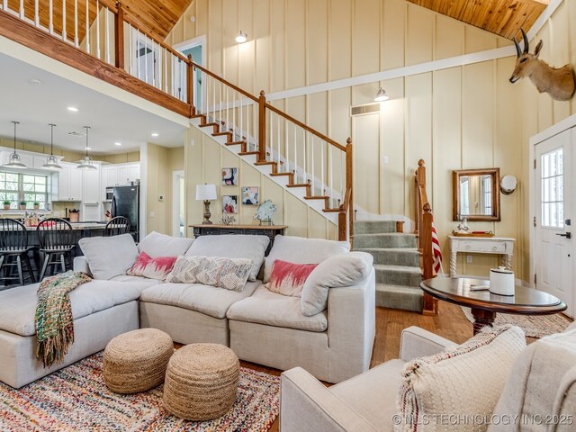 263 Eagles Nest Path, Stigler, OK 74462 - living area featuring high vaulted ceiling, stairs, a healthy amount of sunlight, and wood finished floors