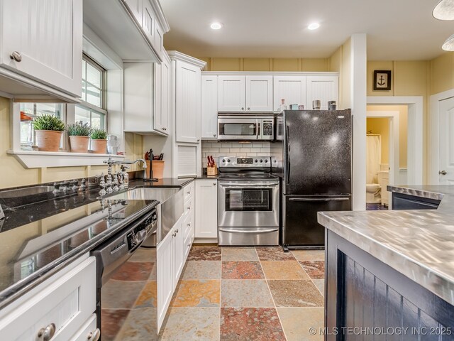 263 Eagles Nest Path, Stigler, OK 74462 - kitchen featuring stone tile flooring, white cabinetry, decorative backsplash, and black appliances