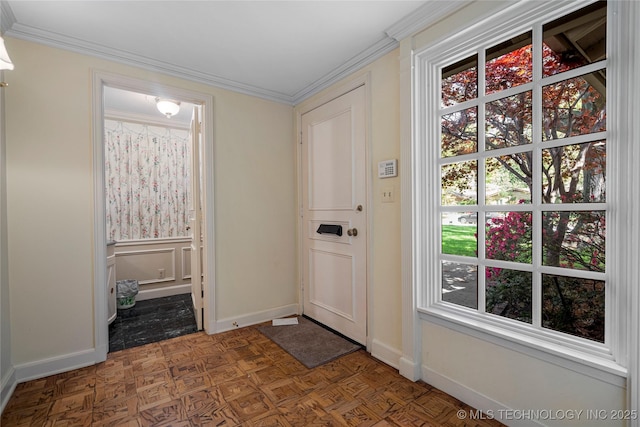 entryway featuring a decorative wall, ornamental molding, and baseboards