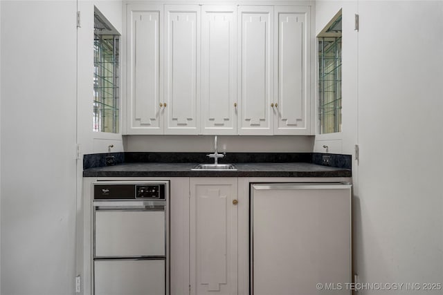 bar with wet bar, stainless steel dishwasher, and a sink