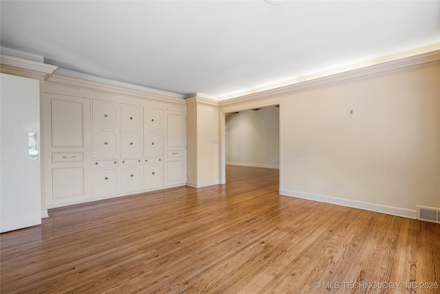 unfurnished room with light wood-type flooring, visible vents, and baseboards
