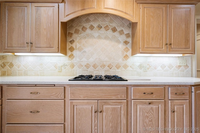 kitchen with backsplash, light brown cabinetry, and black gas stovetop