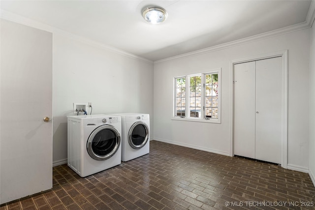 washroom with washing machine and clothes dryer, laundry area, baseboards, ornamental molding, and brick patterned floor