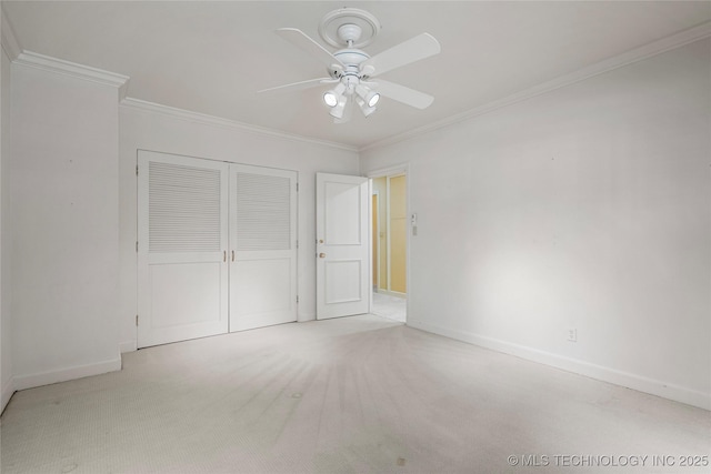 unfurnished bedroom with baseboards, carpet floors, a closet, and crown molding