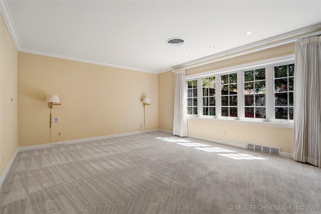 empty room featuring baseboards, visible vents, carpet floors, and crown molding