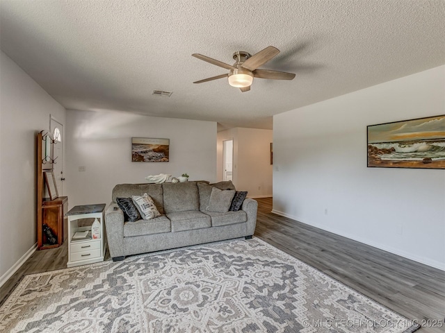 721 Ladd Ave W, Depew, OK 74028 - living area featuring ceiling fan, wood finished floors, a textured ceiling, and baseboards