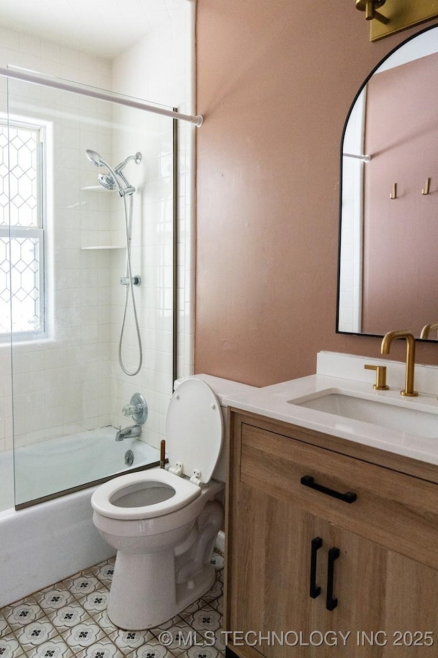 full bathroom featuring toilet, tile patterned floors, vanity, and combined bath / shower with glass door