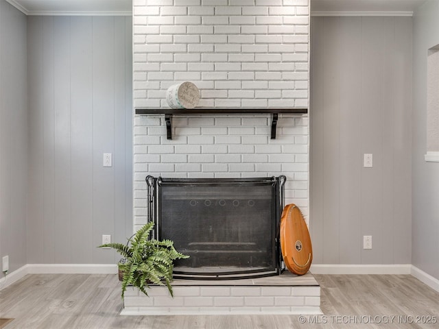 interior details featuring wood finished floors, baseboards, and a brick fireplace
