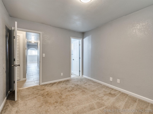 unfurnished bedroom with baseboards and carpet
