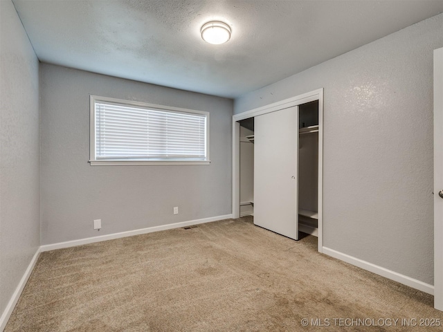 unfurnished bedroom with a closet, baseboards, and carpet