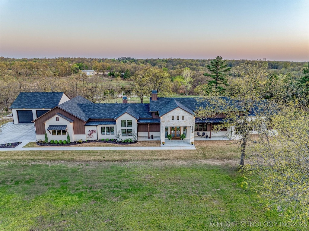 view of front of property with a garage, a yard, and a chimney