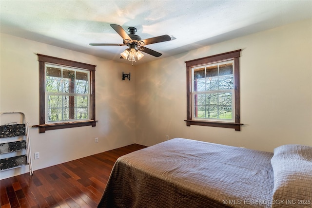 bedroom with multiple windows, a ceiling fan, and wood finished floors