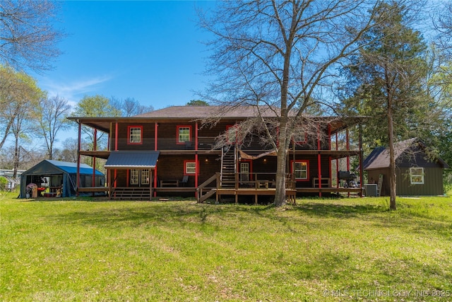 rear view of property with cooling unit, a yard, a deck, and an outbuilding