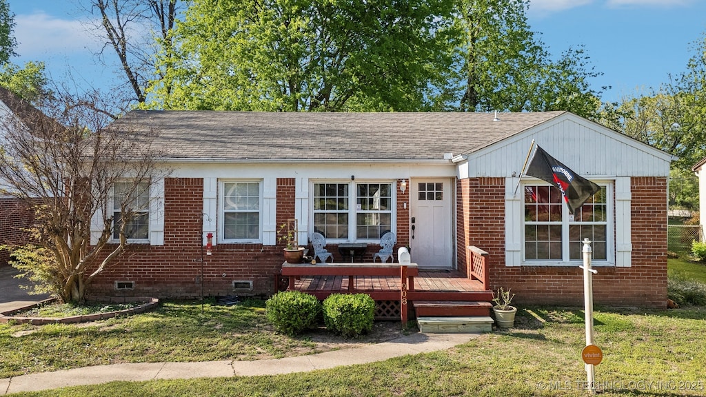 view of front of home with crawl space, a shingled roof, a front lawn, and brick siding