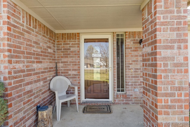 doorway to property with brick siding
