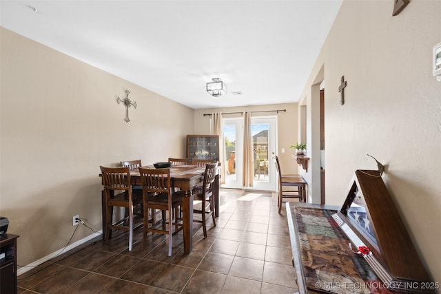 dining area featuring dark tile patterned floors