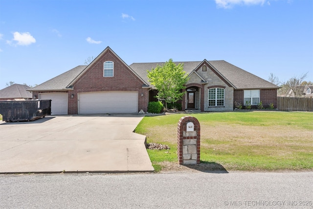 705 SW 20th St, Wagoner, OK 74467 - view of front of house featuring concrete driveway, fence, a front lawn, and brick siding