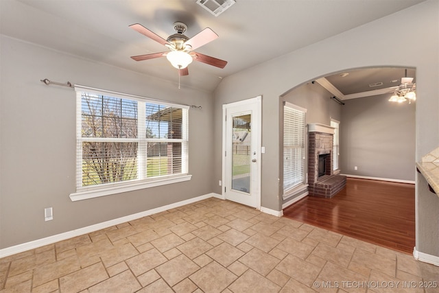 705 SW 20th St, Wagoner, OK 74467 - spare room with baseboards, a ceiling fan, visible vents, stone finish flooring, and arched walkways