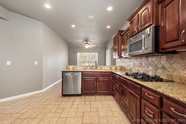 705 SW 20th St, Wagoner, OK 74467 - kitchen with tasteful backsplash, baseboards, a sink, ceiling fan, and stainless steel appliances