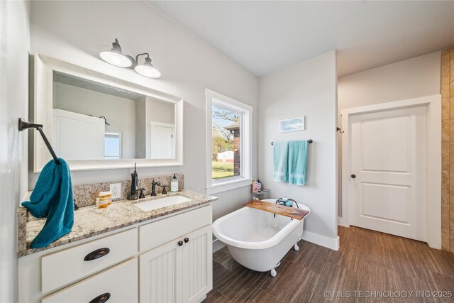 369102 E 960 Road, Road, OK 74833 - full bath with a soaking tub, wood finished floors, vanity, and baseboards