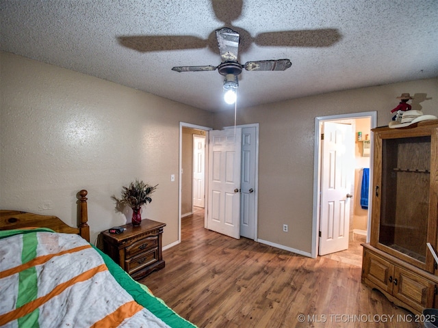 22526 N 2860th Rd, Kingfisher, OK 73750 - bedroom featuring a textured wall, baseboards, wood finished floors, and a textured ceiling