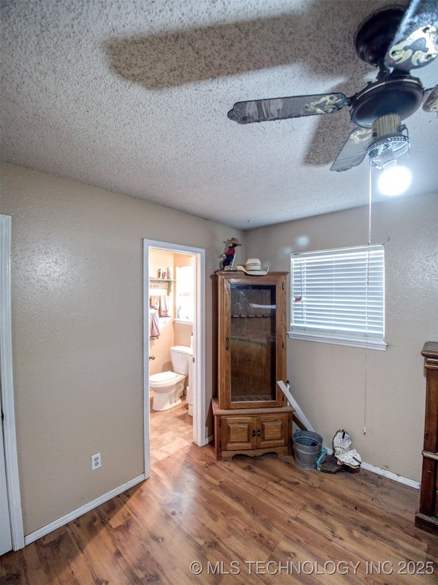 22526 N 2860th Rd, Kingfisher, OK 73750 - unfurnished living room with a textured ceiling, wood finished floors, baseboards, and a ceiling fan