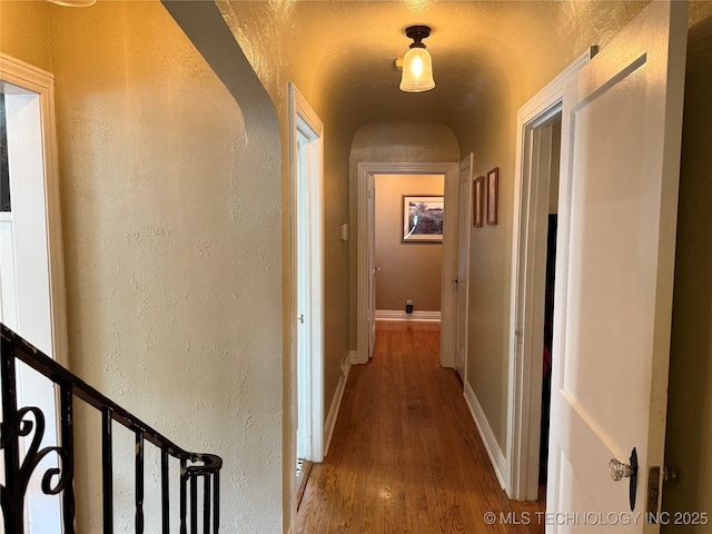 1400 Hillcrest, Bartlesville, OK 74003 - hallway featuring wood finished floors, a textured wall, baseboards, and arched walkways