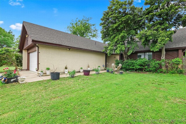 6370 S 29th W Pl, Tulsa, OK 74132 - back of house featuring stucco siding, a lawn, roof with shingles, and an attached garage