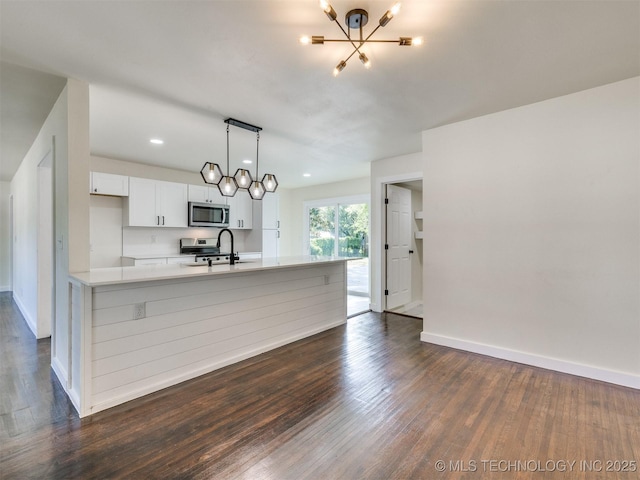 4916 S Cincinnati Ave, Tulsa, OK 74105 - kitchen with appliances with stainless steel finishes, dark wood-type flooring, a chandelier, and light countertops
