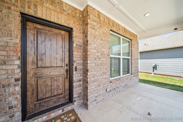 doorway to property featuring brick siding