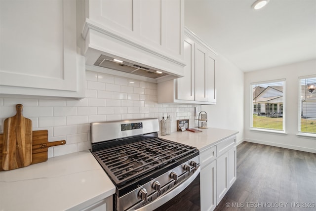kitchen with custom range hood, tasteful backsplash, stainless steel gas range oven, and white cabinetry