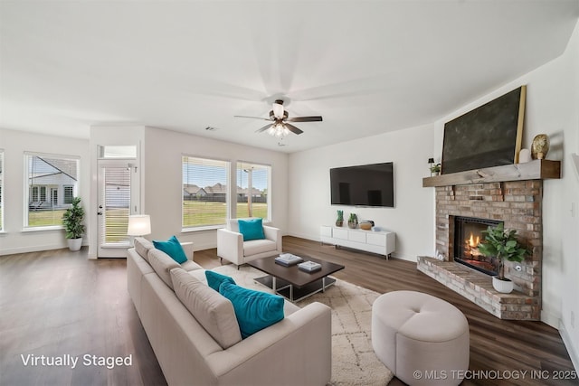 living room featuring a fireplace, baseboards, a ceiling fan, and wood finished floors
