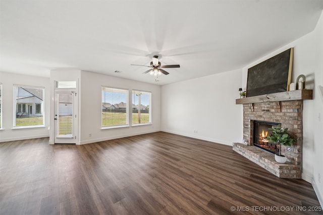 unfurnished living room featuring dark wood-style flooring, a fireplace, a ceiling fan, and baseboards
