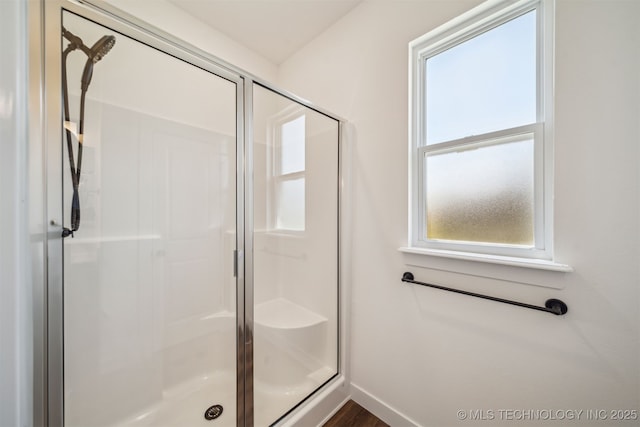 bathroom with baseboards and a stall shower
