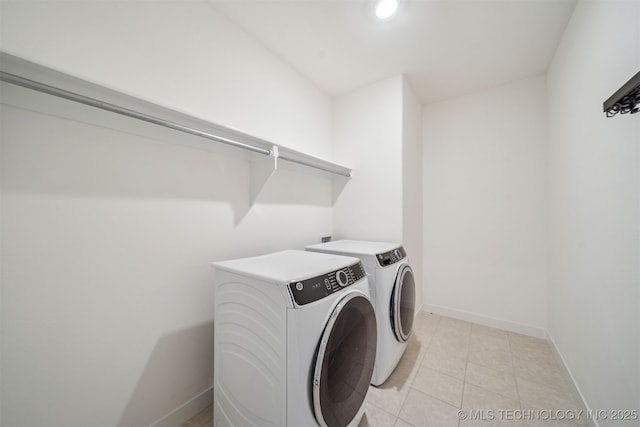 laundry area featuring baseboards, laundry area, recessed lighting, washer and clothes dryer, and light tile patterned flooring